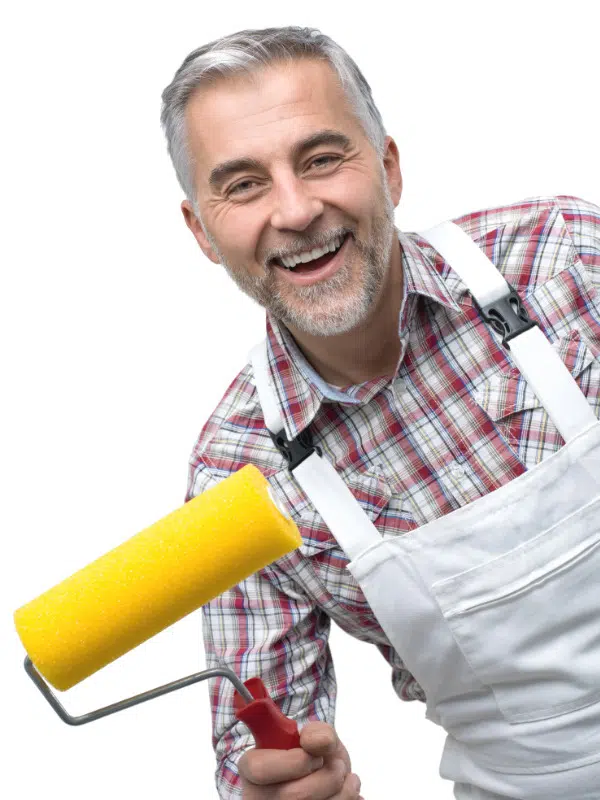 Personne souriante avec rouleau de peinture neuf