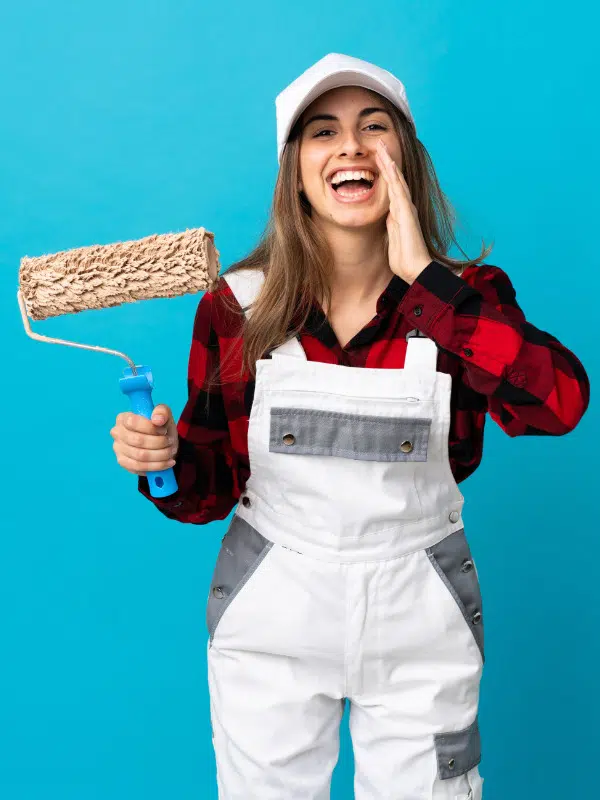 Femme qui crit en tenue de peintre avec rouleau de peinture à la main