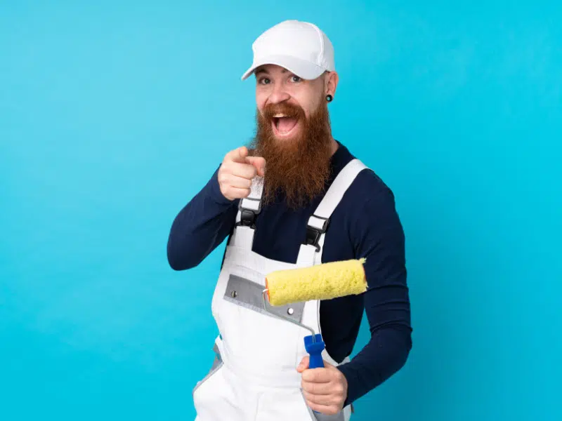 Peintre en joie avec un rouleau de peinture à la main