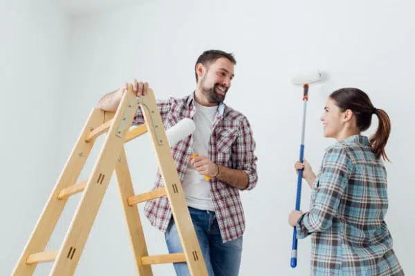 Couple avec rouleaux de peinture à la main